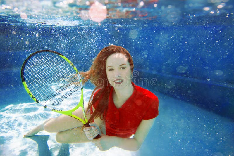 Young Beautiful Girl Playing Tennis Underwater In The S