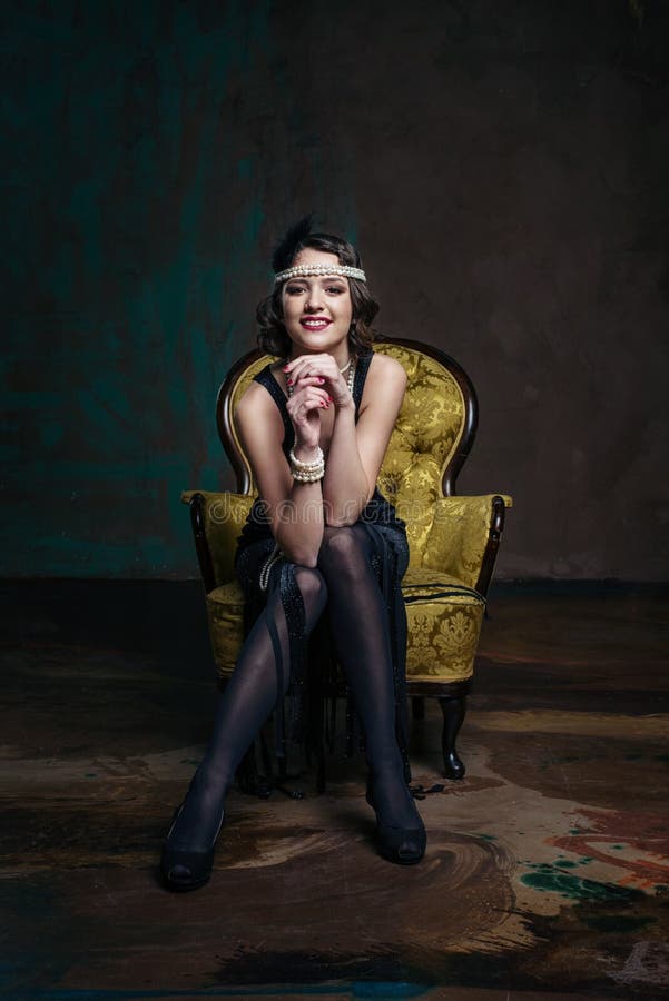 Young beautiful girl in red dress style of the 20`s or 30`s with glass of martini near the piano. Vintage style beautiful woman. stock images Young beautiful girl in red dress style of the 20`s or 30`s with glass of martini near the piano. Vintage style beautiful woman. stock images