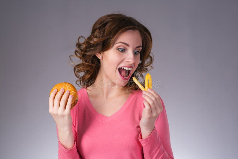 Young Beautiful Girl with a Sandwich and a French Fries from a F Stock