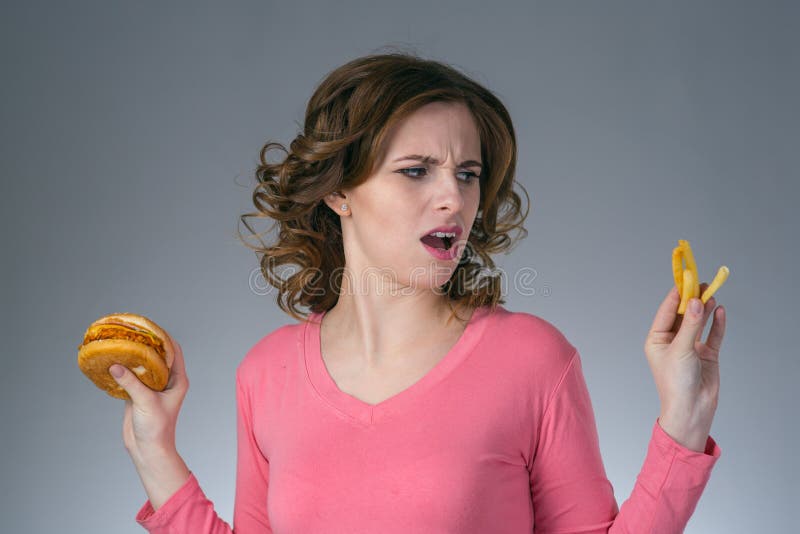 Young Beautiful Girl with a Sandwich and a French Fries from a F Stock