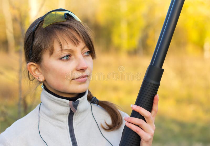 Young beautiful girl with a shotgun