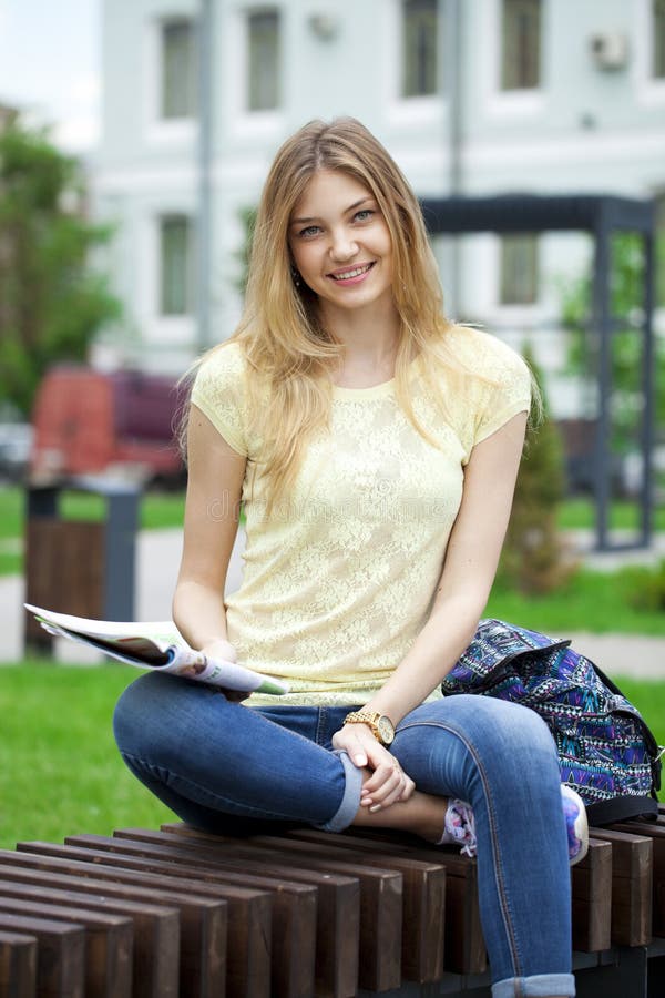 Young Beautiful Girl Sitting On A Bench In The Summer Park Stock Image