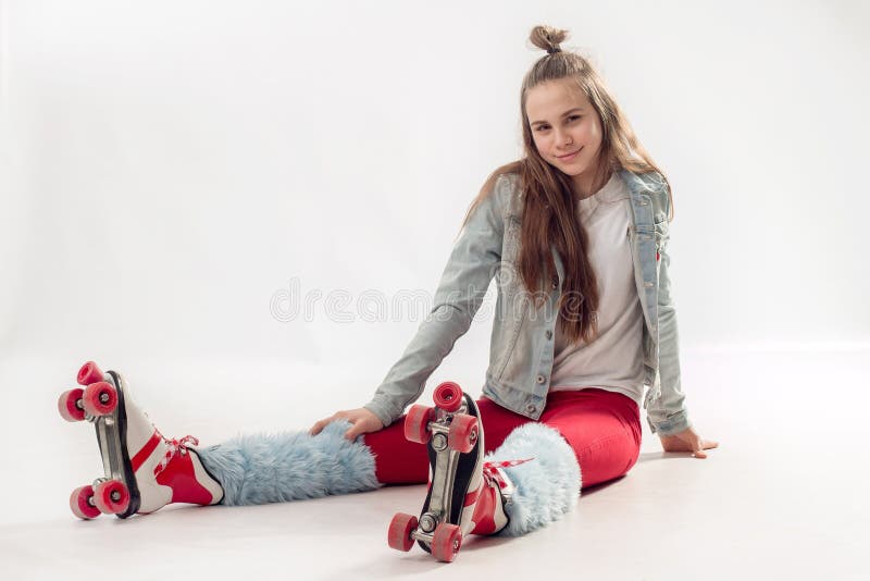 Young beautiful girl in sporty stylish clothes with long hair on four-wheeled rollers isolated on background royalty free stock photos Young beautiful girl in sporty stylish clothes with long hair on four-wheeled rollers isolated on background royalty free stock photos