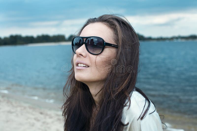 Young beautiful girl in sun glasses on a beach