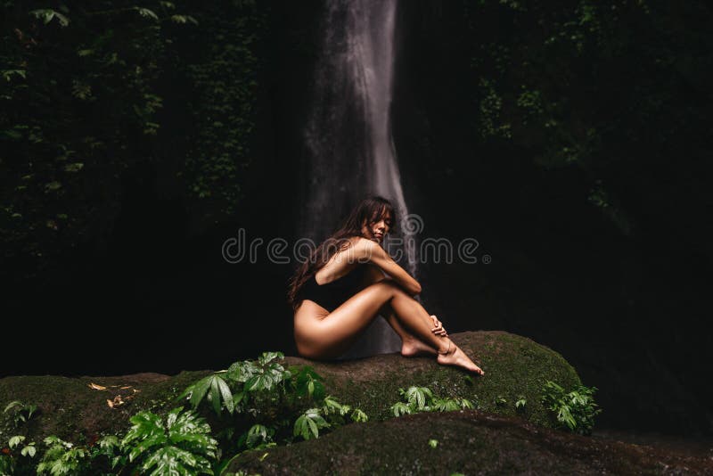 Young and beautiful girl taking bath in a waterfall. Young and beautiful girl taking bath in a waterfall