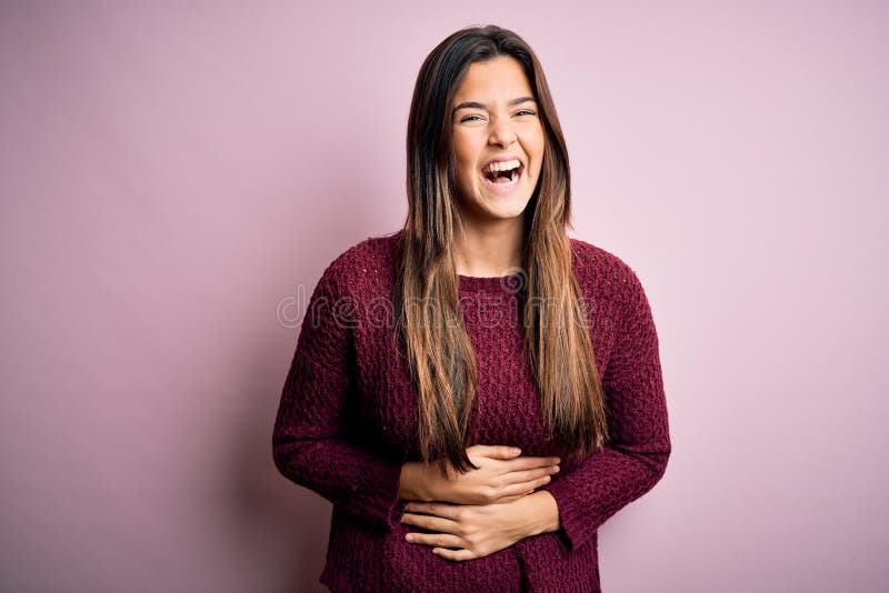 Young beautiful girl wearing casual sweater over isolated pink background smiling and laughing hard out loud because funny crazy