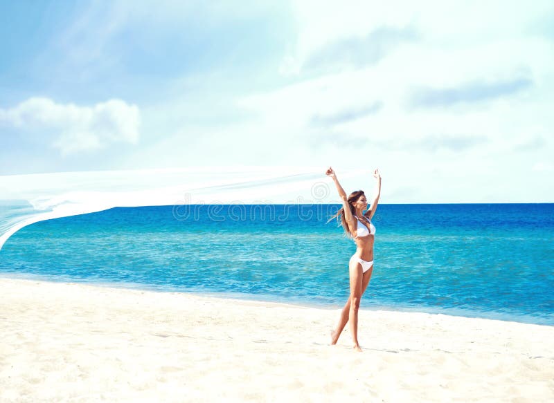 Young and beautiful girl in white swim suit posing on beach. Travel, resort, vacation, concept.