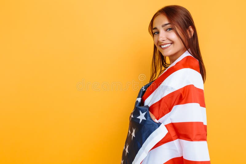 Young beautiful girl in a white t-shirt with the American flag, on a yellow background stock images Young beautiful girl in a white t-shirt with the American flag, on a yellow background stock images