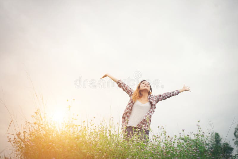 Young beautiful hipster woman in a flower field at sunset. Freed