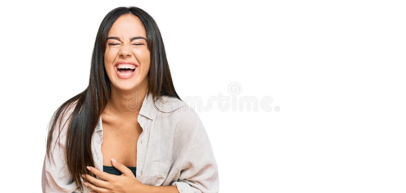 Young beautiful hispanic girl wearing casual clothes smiling and laughing hard out loud because funny crazy joke with hands on