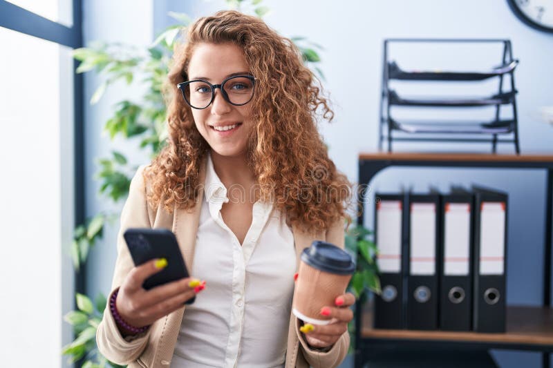 Young beautiful hispanic woman business worker using smartphone drinking coffee at office royalty free stock photography