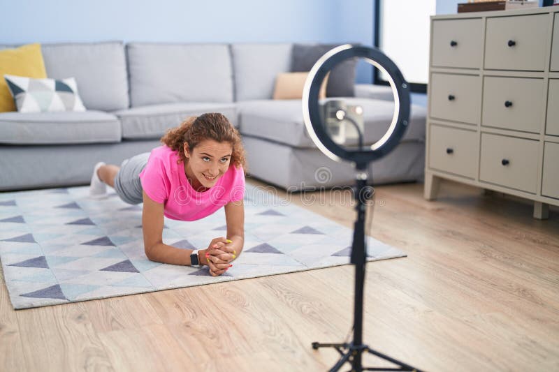 Young beautiful hispanic woman smiling confident having online core exercise class at home royalty free stock image