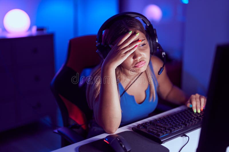 Young beautiful hispanic woman streamer stressed using computer at gaming room stock images