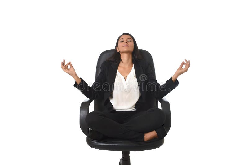 Young beautiful latin american business woman sitting at office chair in lotus posture practicing yoga