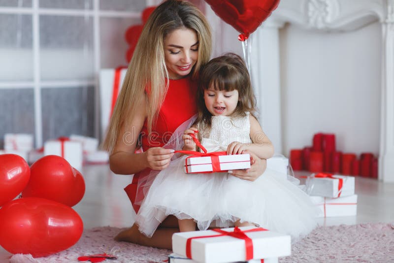 Happy mother and daughter parses gifts on Valentine`s Day