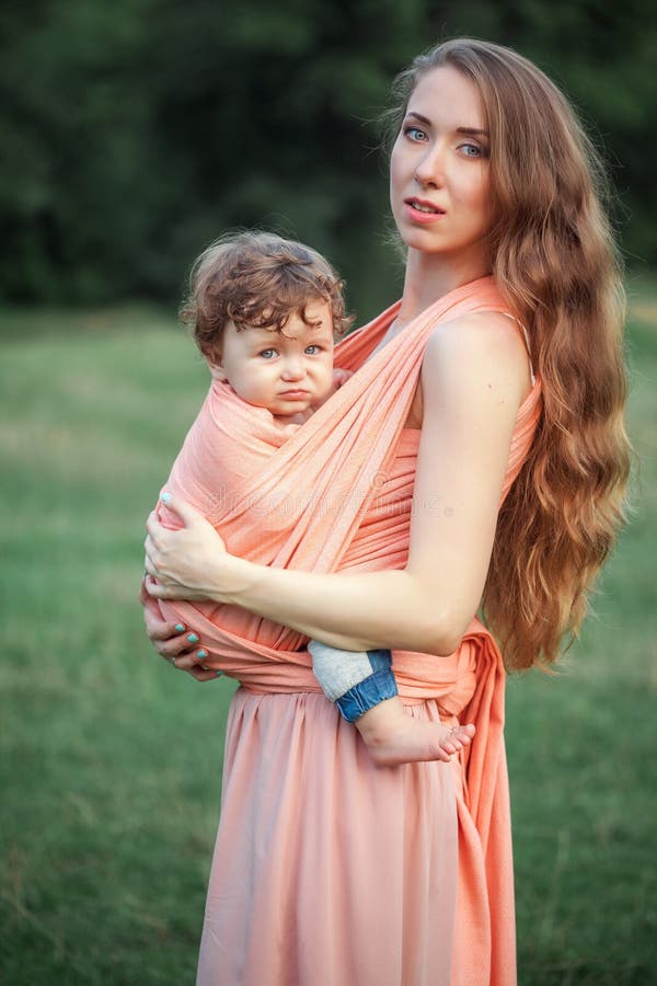 Young beautiful mother hugging her little toddler son against green grass. Happy woman with her baby boy on a summer royalty free stock photo Young beautiful mother hugging her little toddler son against green grass. Happy woman with her baby boy on a summer royalty free stock photo