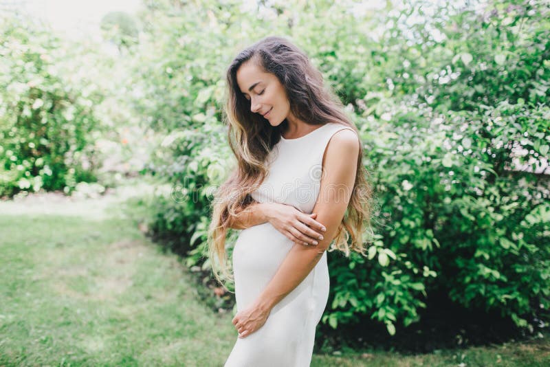 Young Beautiful Pregnant Woman with Long Healthy Curly Hair Posing in a ...