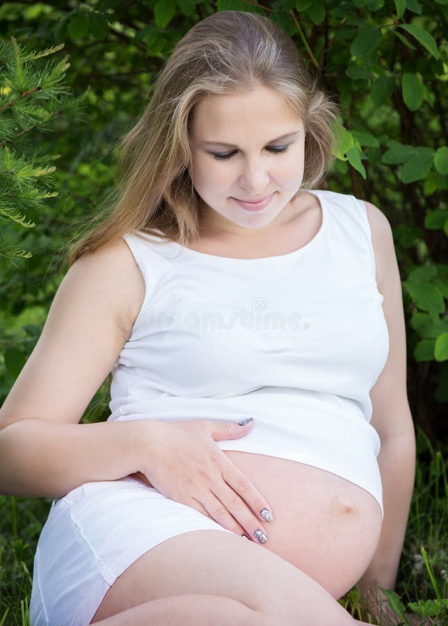 Young beautiful pregnant woman relaxing in nature