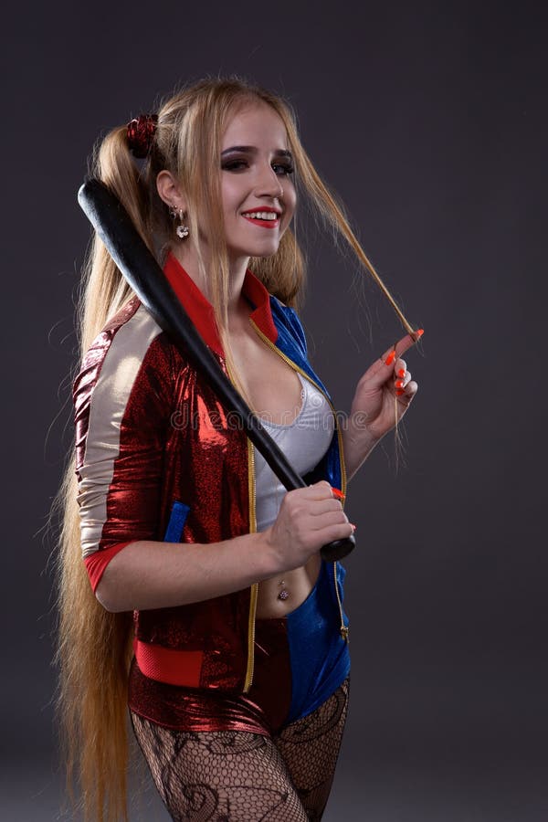 Ragazza in costume Harley Quinn. Essa si erge con una mazza e si lecca il  bat. Close up. Cosplay Foto stock - Alamy