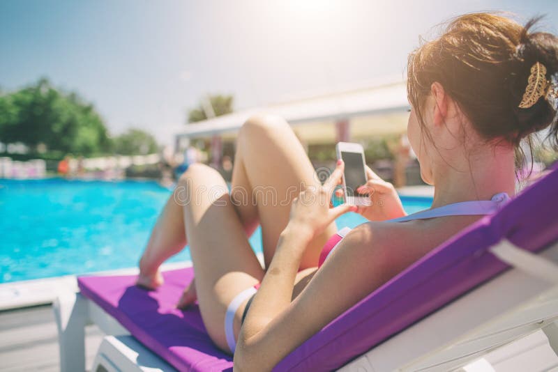 Young beautiful smiling woman in bikini in warm pool on resort and talk in mobile phone. royalty free stock images Young beautiful smiling woman in bikini in warm pool on resort and talk in mobile phone. royalty free stock images
