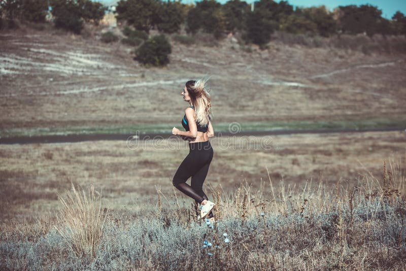 Young beautiful sportive girl runing. Girl is exercising. Outdoor sport. Beautiful strong sexy athletic caucasian fitness woman. Y stock photo Young beautiful sportive girl runing. Girl is exercising. Outdoor sport. Beautiful strong sexy athletic caucasian fitness woman. Y stock photo