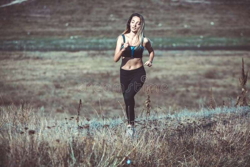 Young beautiful sportive girl runing. Girl is exercising. Outdoor sport. Beautiful strong sexy athletic caucasian fitness woman. Y stock photos Young beautiful sportive girl runing. Girl is exercising. Outdoor sport. Beautiful strong sexy athletic caucasian fitness woman. Y stock photos