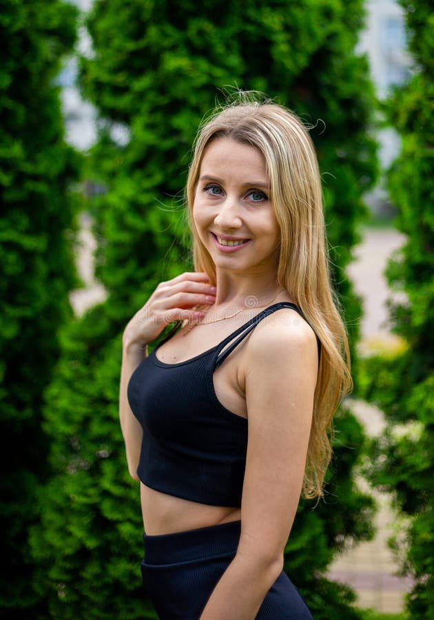 Young Beautiful Sporty Blonde Woman in a Black T-shirt and in Black ...