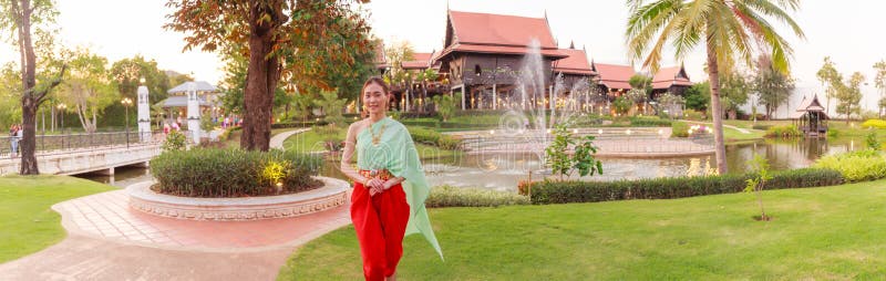 Young Beautiful Thai Asian woman dressing in vintage retro Traditional Thai costume in wait to welcome guest. Thailand Cultural royalty free stock image Young Beautiful Thai Asian woman dressing in vintage retro Traditional Thai costume in wait to welcome guest. Thailand Cultural royalty free stock image