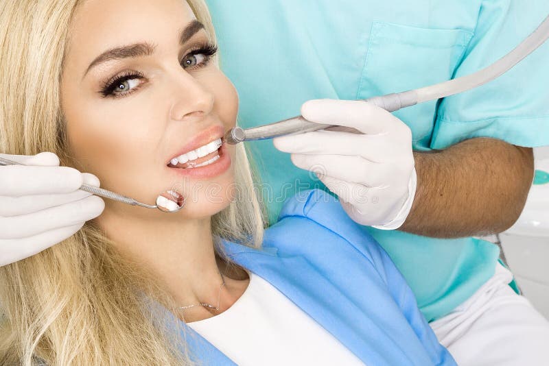Young beautiful woman with beautiful white teeth sitting on a de stock images Young beautiful woman with beautiful white teeth sitting on a de stock images