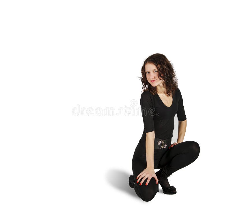 Young beautiful woman in black suit posing crouching