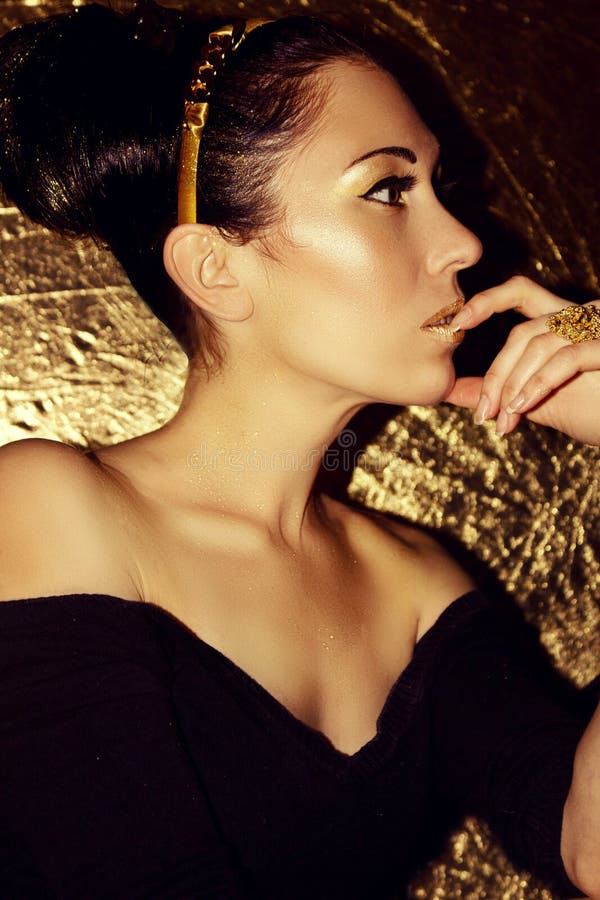 Young beautiful woman brunette with retro hairstyle, hoop. Gold make-up. stock photos Young beautiful woman brunette with retro hairstyle, hoop. Gold make-up. stock photos