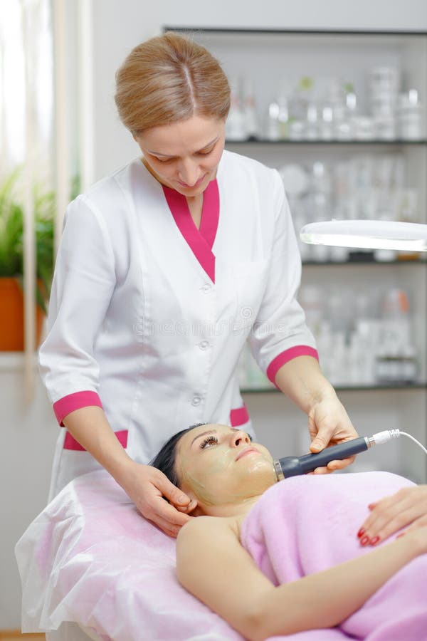 Young beautiful woman with dark hair gets procedure in the beauty salon