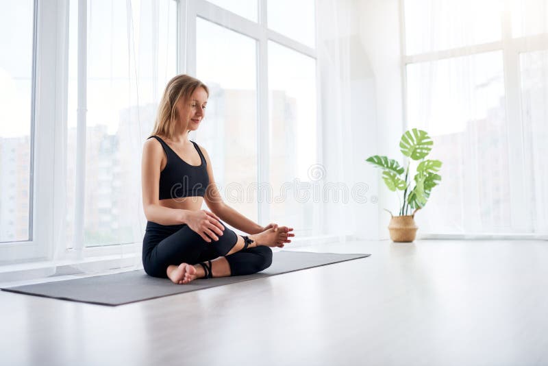 Young Beautiful Woman Doing Yoga in a Modern Bright Room with Large ...