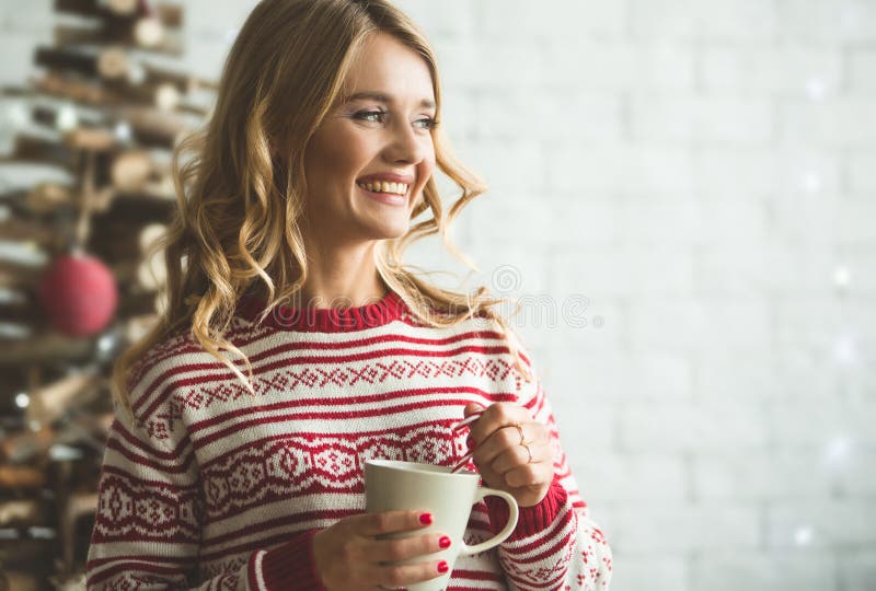 Young beautiful woman drinking cup of coffee blurred winter snow tree background.