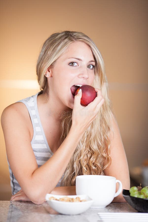 Young beautiful woman enjoying healthy breakfast in the kitchen