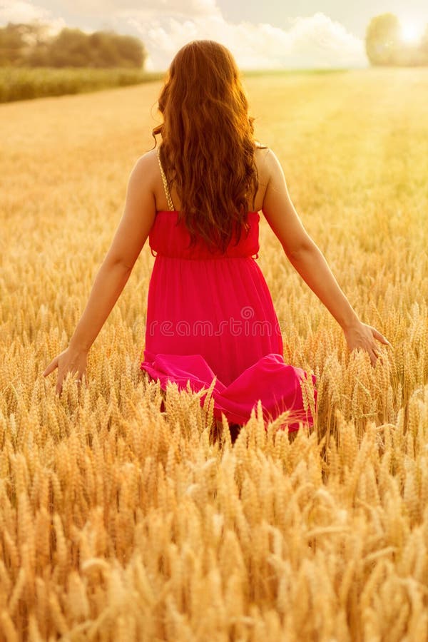 Young beautiful woman in field of wheat