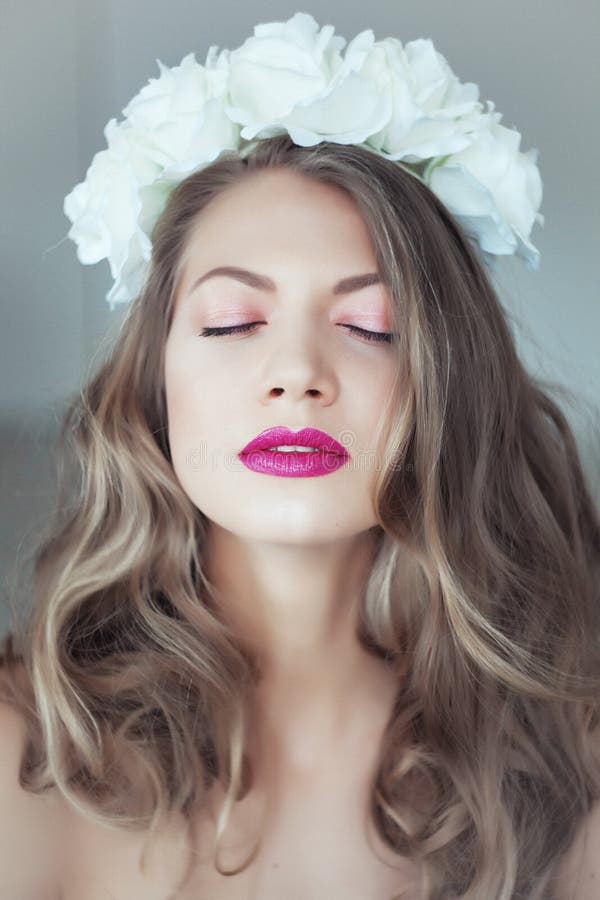 Young beautiful woman with flowers in hair and blue eyes