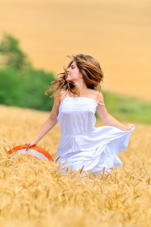 Young beautiful woman in golden wheat field stock images