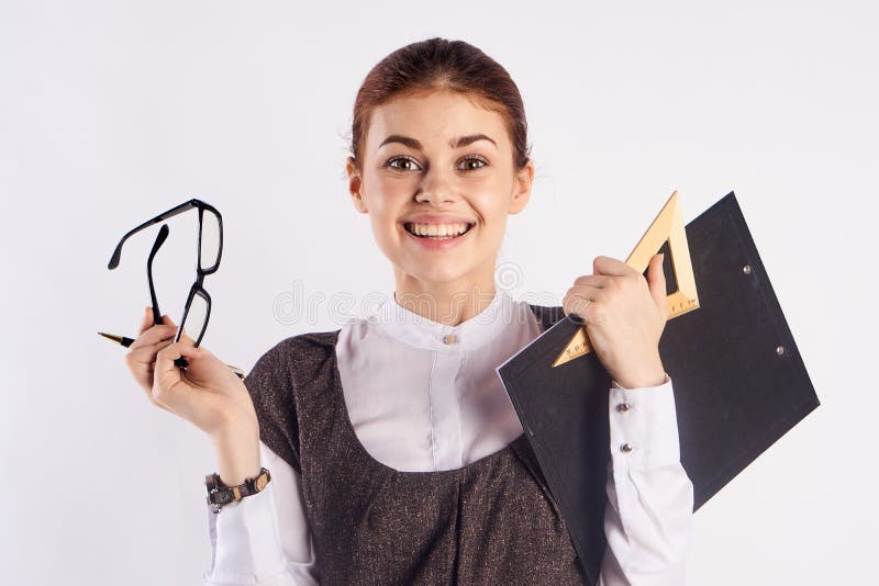 Young beautiful woman holds glasses and documents on white background, portrait, teacher, smile royalty free stock photography