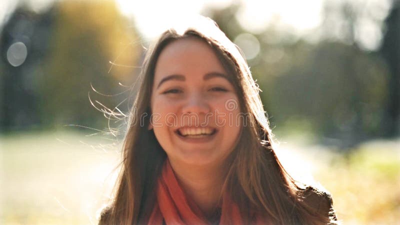 Young Beautiful Woman Lauighing and Looking at the Camera, Autumn Background in Sunny Day. Smiling Happy Girl Portrait.