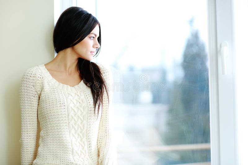 Young beautiful woman looking at window stock images