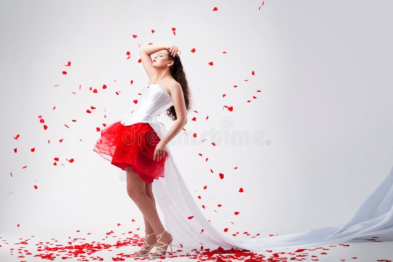 Young beautiful woman with petals of roses