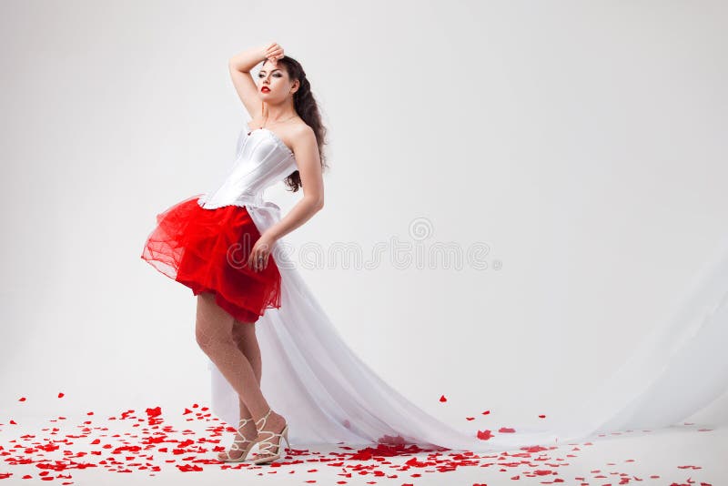 Young beautiful woman with petals of roses