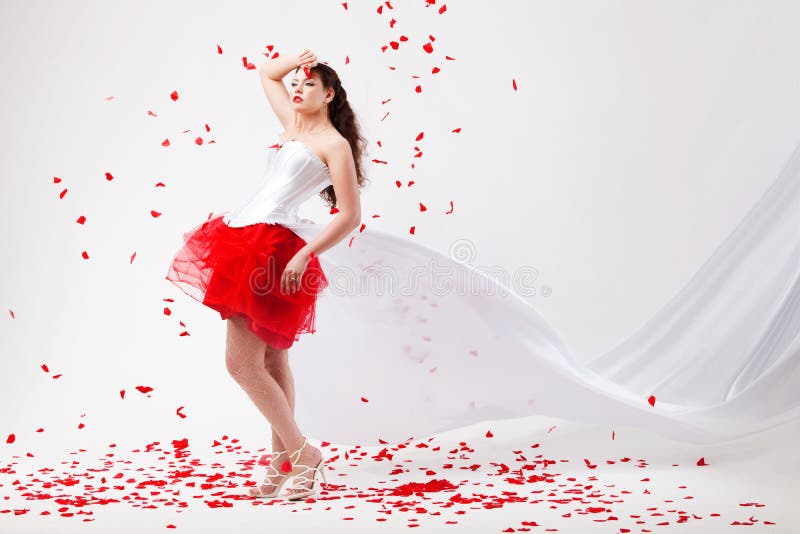 Young beautiful woman with petals of roses