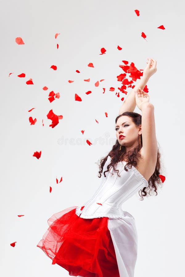 Young beautiful woman with petals of roses