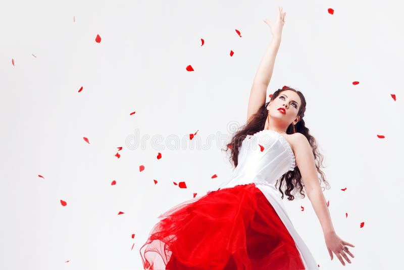 Young beautiful woman with petals of roses