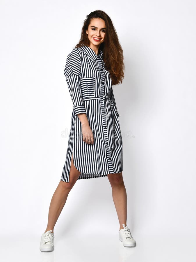 Young beautiful woman posing in new design casual summer stripped jeans dress full body on grey stock photography Young beautiful woman posing in new design casual summer stripped jeans dress full body on grey stock photography