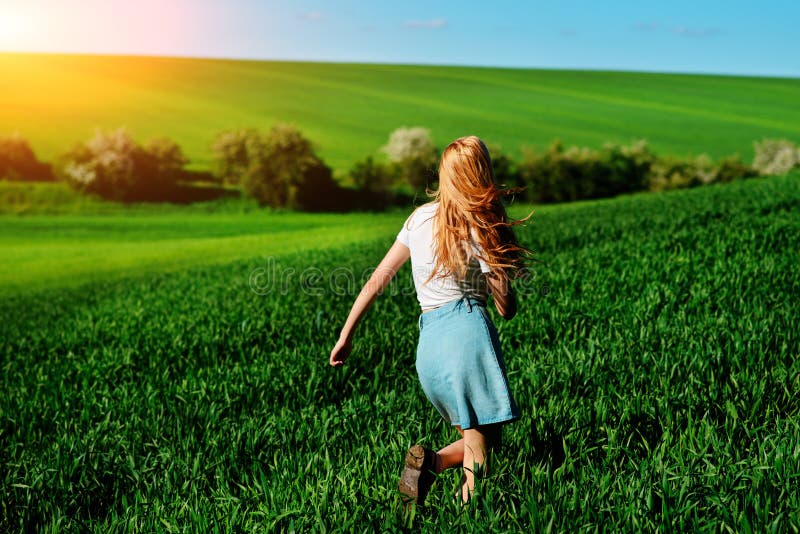 Young beautiful woman running on a green field. Lifestyle, activity.