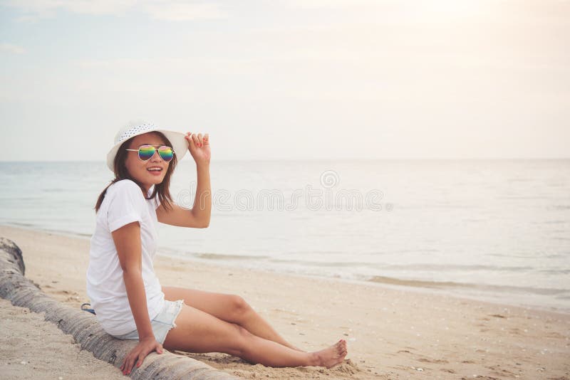 Young Beautiful Woman Sitting on the Beach Wearing Sunglasses. F Stock ...