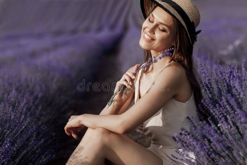 Young beautiful woman sitting in lavender field